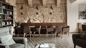 A modern interior with a stone wall, a wooden bench, and a checkered floor. - 19 Rooms (Valletta)