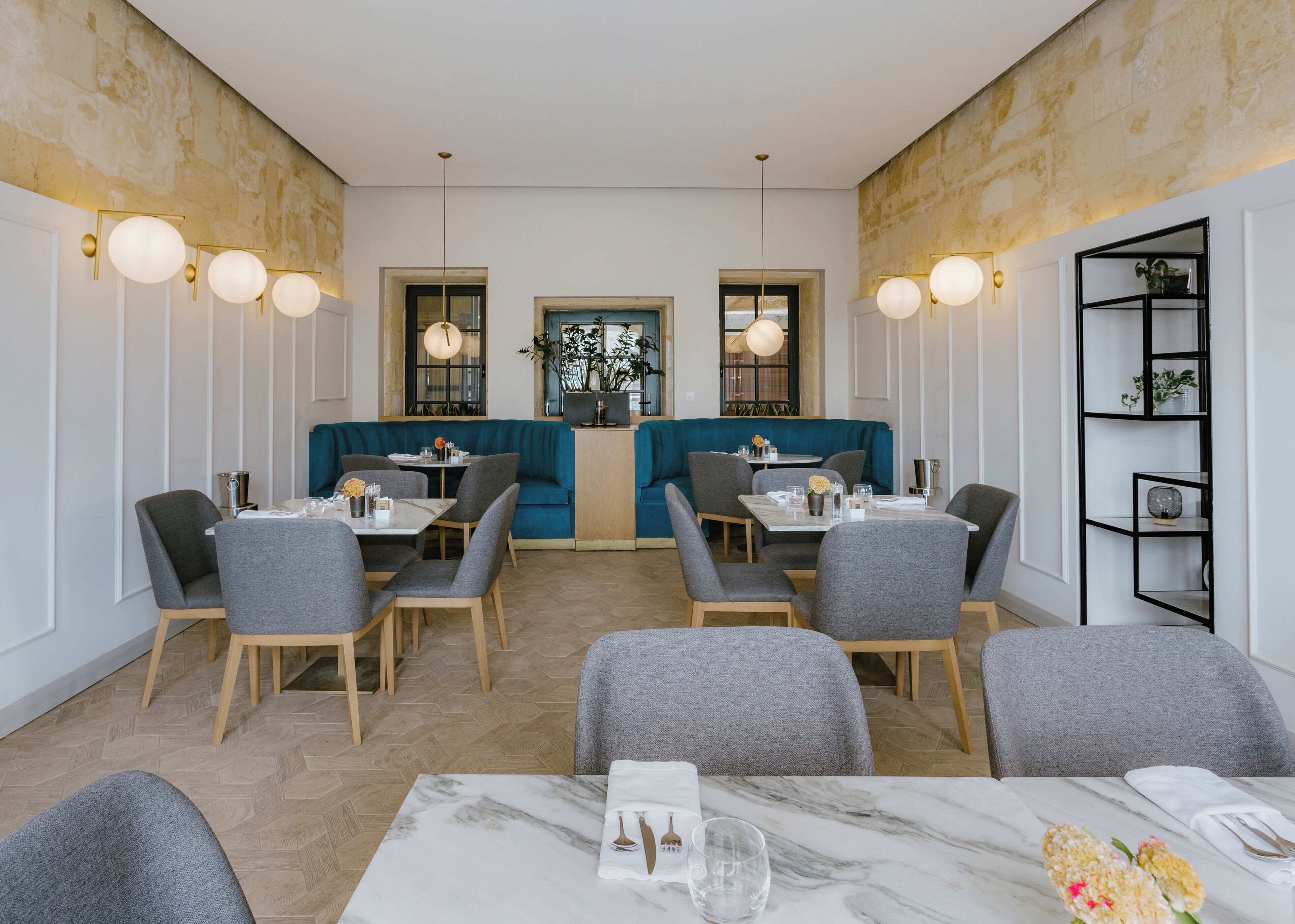 A restaurant with a central seating area, tables with chairs, and a bar area.