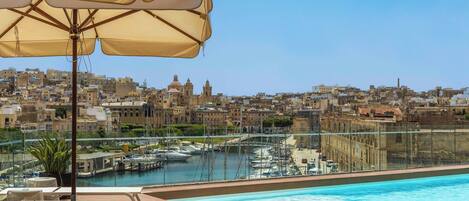 Een seizoensgebonden buitenzwembad, parasols voor strand/zwembad