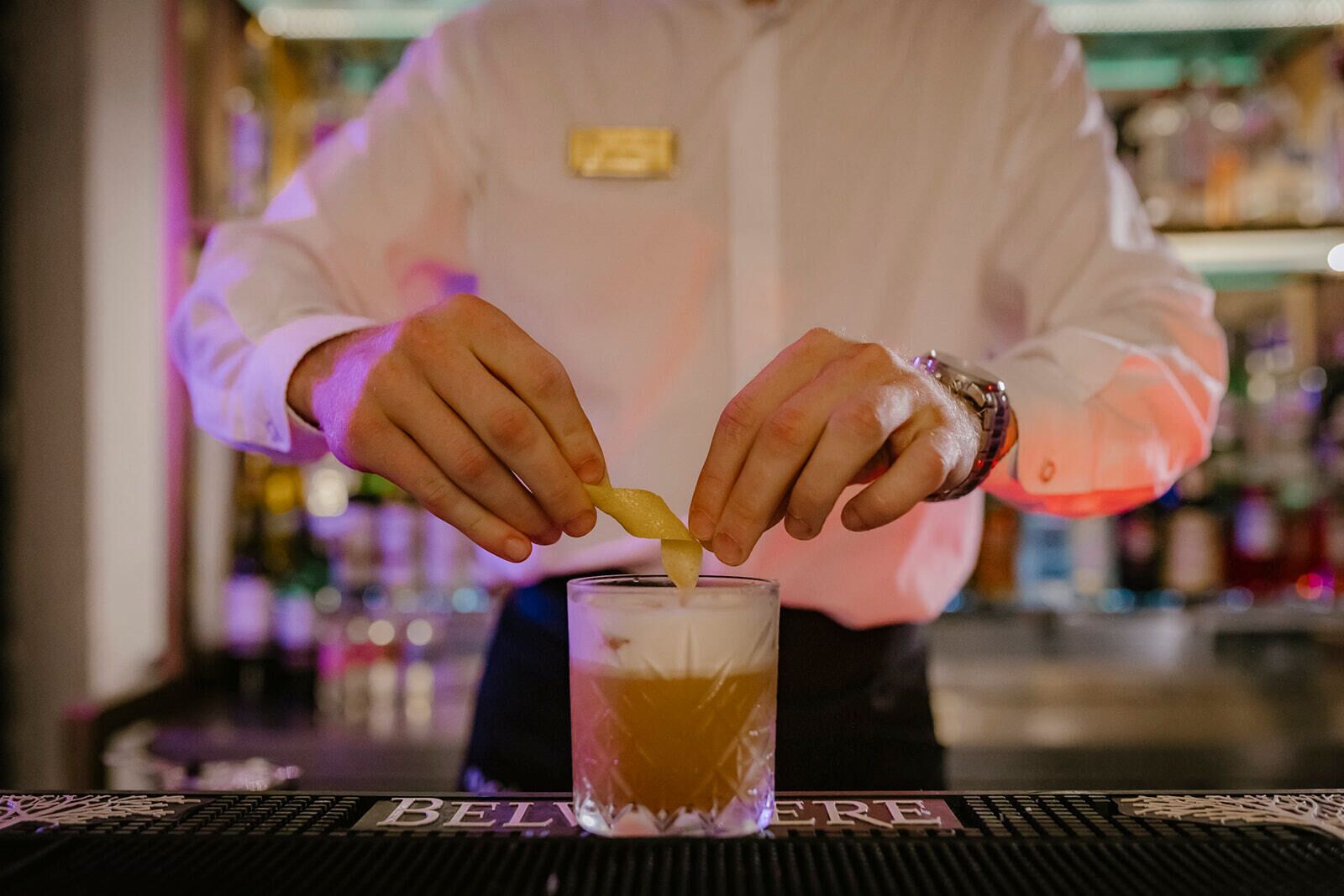 A bartender preparing a drink at a bar.
