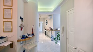 A hallway with a desk, chair, and a plant. - Residenza Borbonica (Naples)