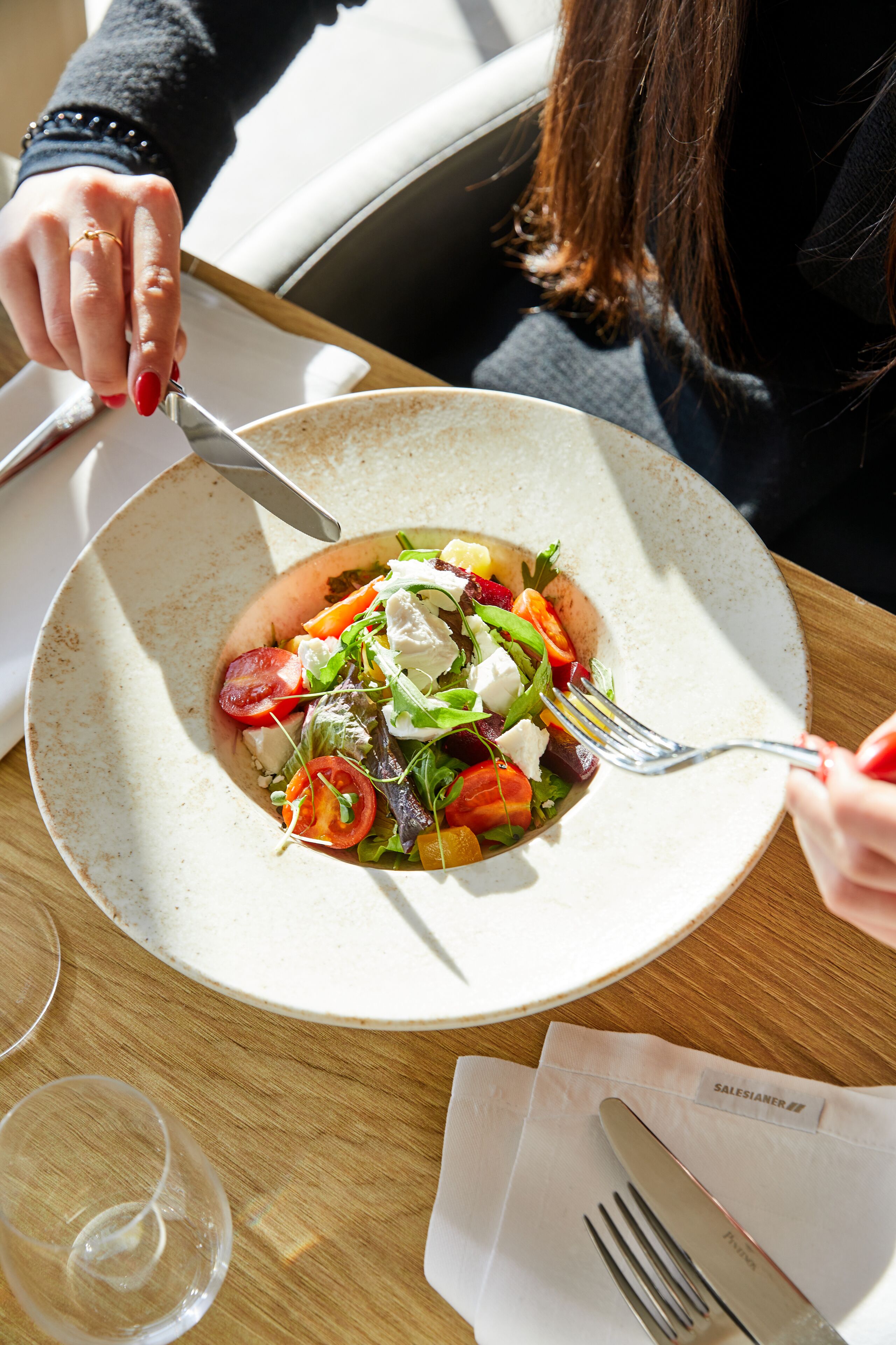 Ein Salat mit Gabel und Messer auf einem Tisch.