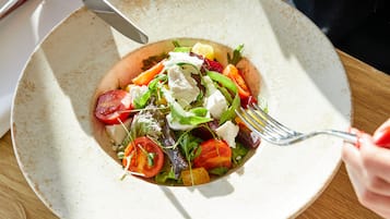 Ein Salat mit Gabel und Messer auf einem Tisch.