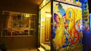 A building with a colorful stained glass window featuring a dragon and a woman. - Strawberry Milk B&B (Taitung)