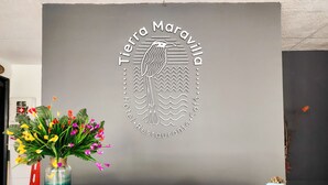 A reception desk with a logo for 'Tierra Maravilla Hotel Restaurante Café'. - Hotel Tierra Maravilla (Salento)