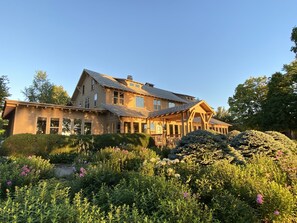 A large, two-story house with a prominent porch and a well-maintained garden in front. - Peters Sunset Beach Resort (Glenwood)