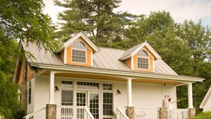 A two-story house with a front porch, stone foundation, and a large tree in the background. - Sugar Hill Inn (Sugar Hill)
