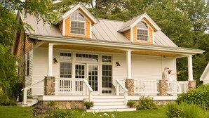 A two-story house with a porch, stone foundation, and a covered front entrance. - Sugar Hill Inn (Sugar Hill)
