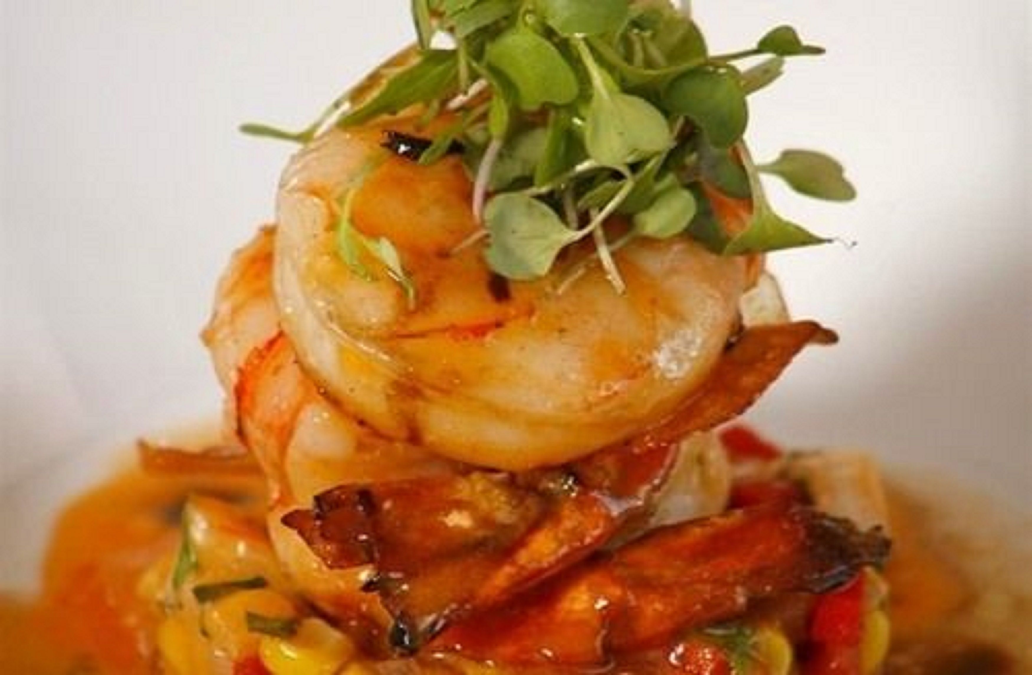 Un plato con camarones y verduras.