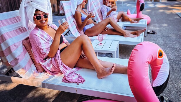 Un espace aménagé au bord de la piscine, avec des chaises longues et un flotteur en forme de flamant rose.