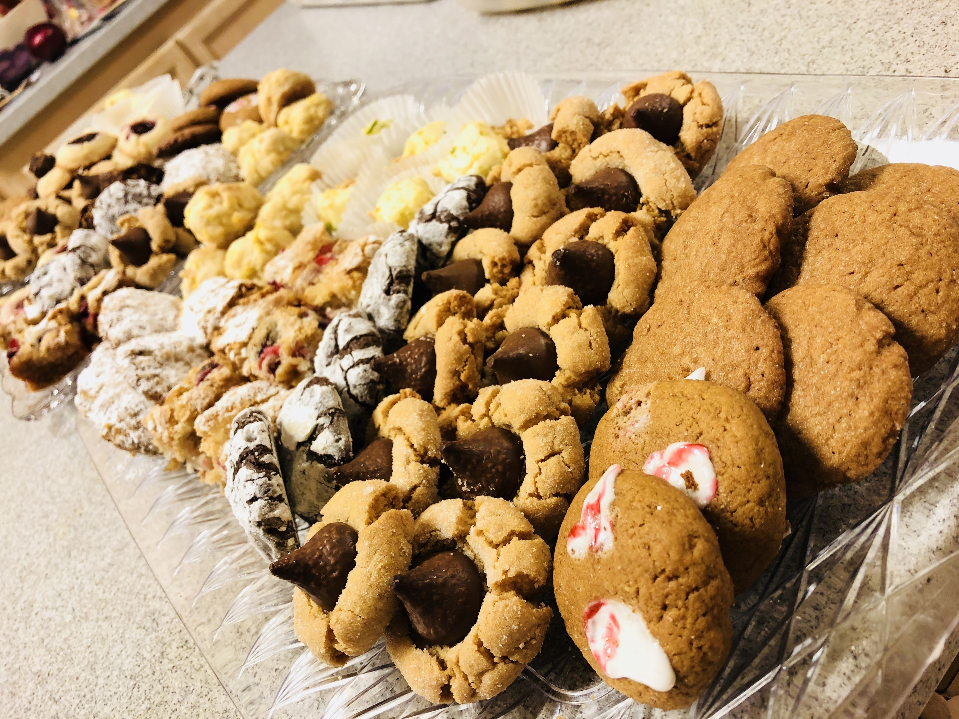 A variety of cookies and pastries on a glass tray.
