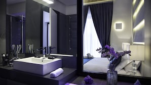 Un bany modern amb un mirall gran, un lavabo blanc i un ram de flors.