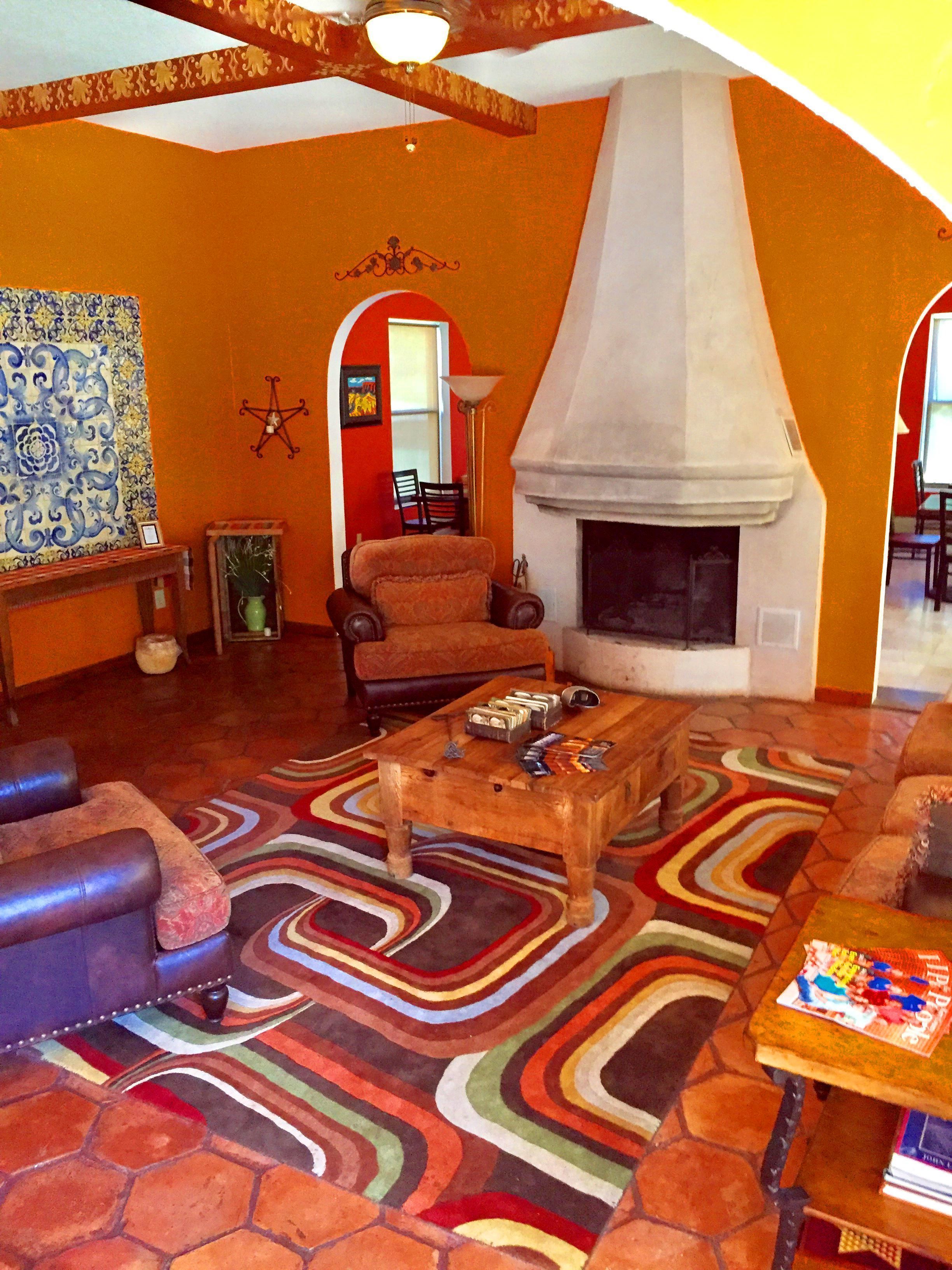 A living room with a fireplace, leather sofas, a patterned rug, and a coffee table.