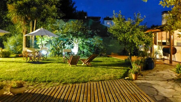 A well-lit outdoor area with a wooden deck, a covered seating area, and a barbecue grill. - Hotel Turingia (Miramar)