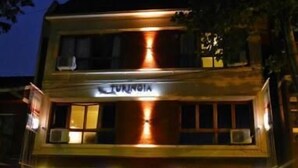 A two-story building with the sign "Turinoga" on the front. There are parked cars in front, and the building has multiple windows and balconies. - Hotel Turingia (Miramar)