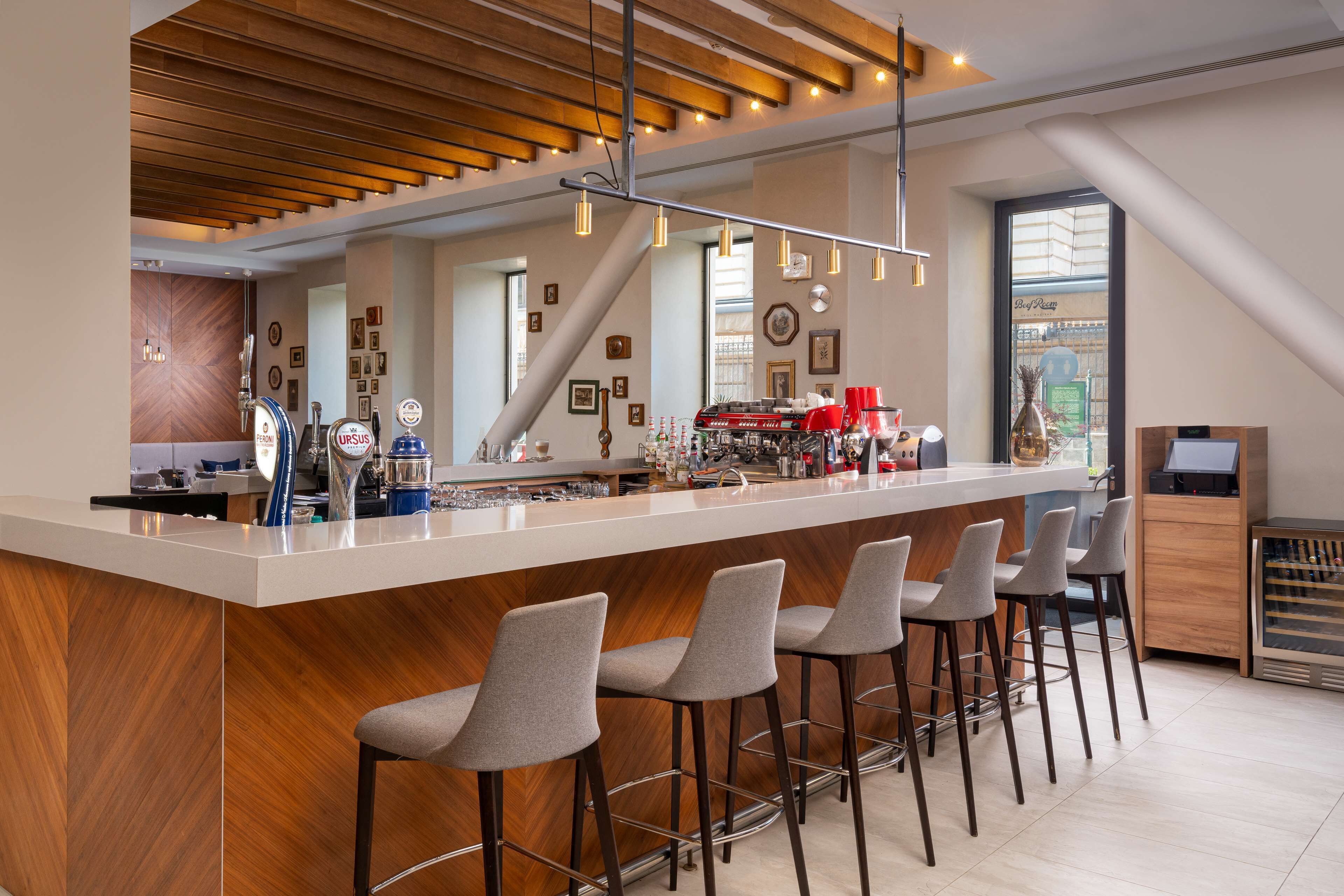 Una cocina moderna con barra, techo de madera y taburetes de bar.