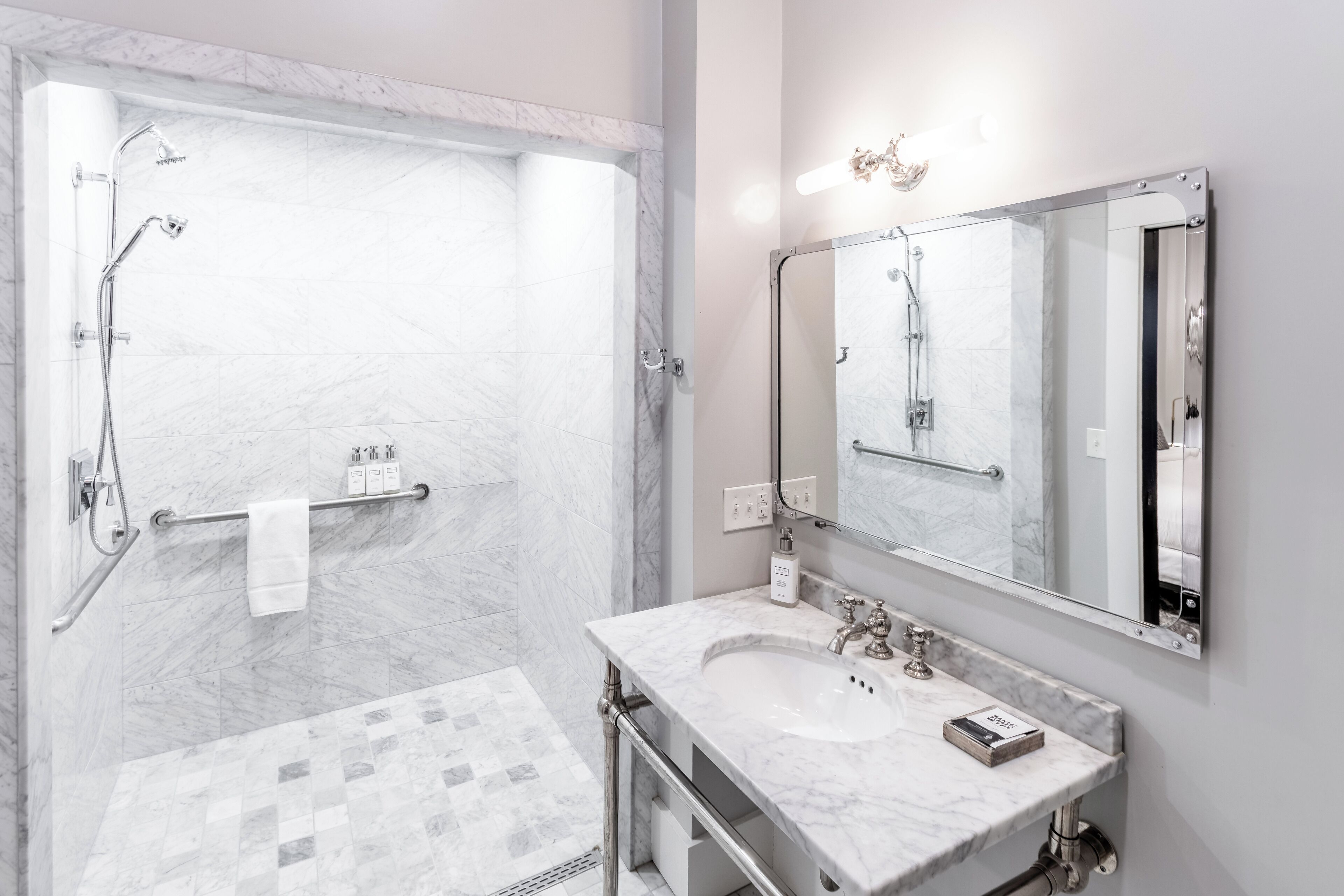 A modern bathroom with a shower, a sink, and a mirror.