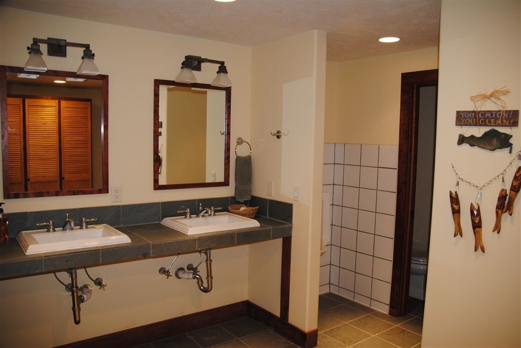 A bathroom with two sinks, a mirror, and a towel rack.