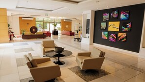 A modern lobby with a seating area, a coffee table, and a wall with colorful artwork.