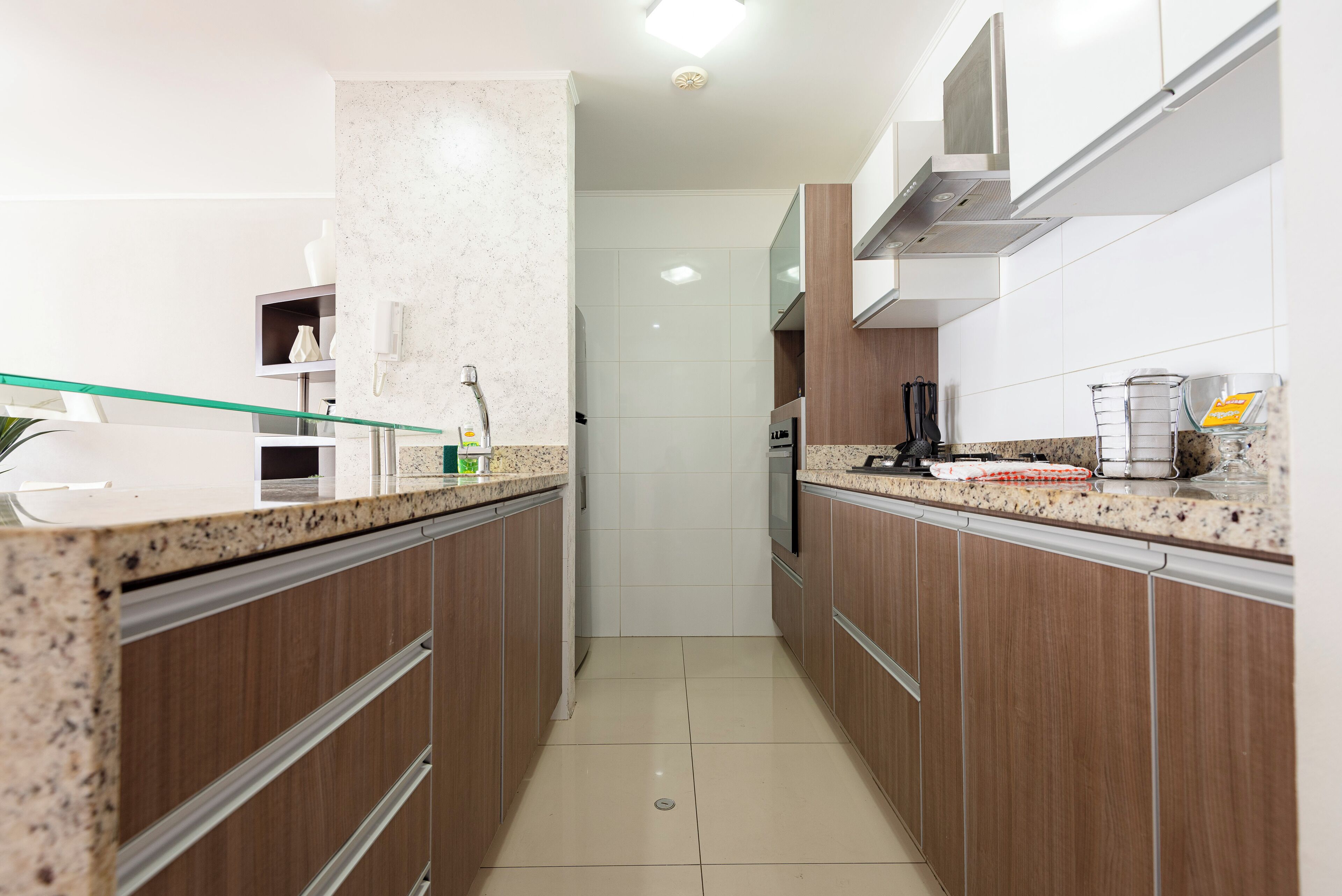 Una cocina moderna con armarios de madera, encimera de granito y electrodomésticos de acero inoxidable.
