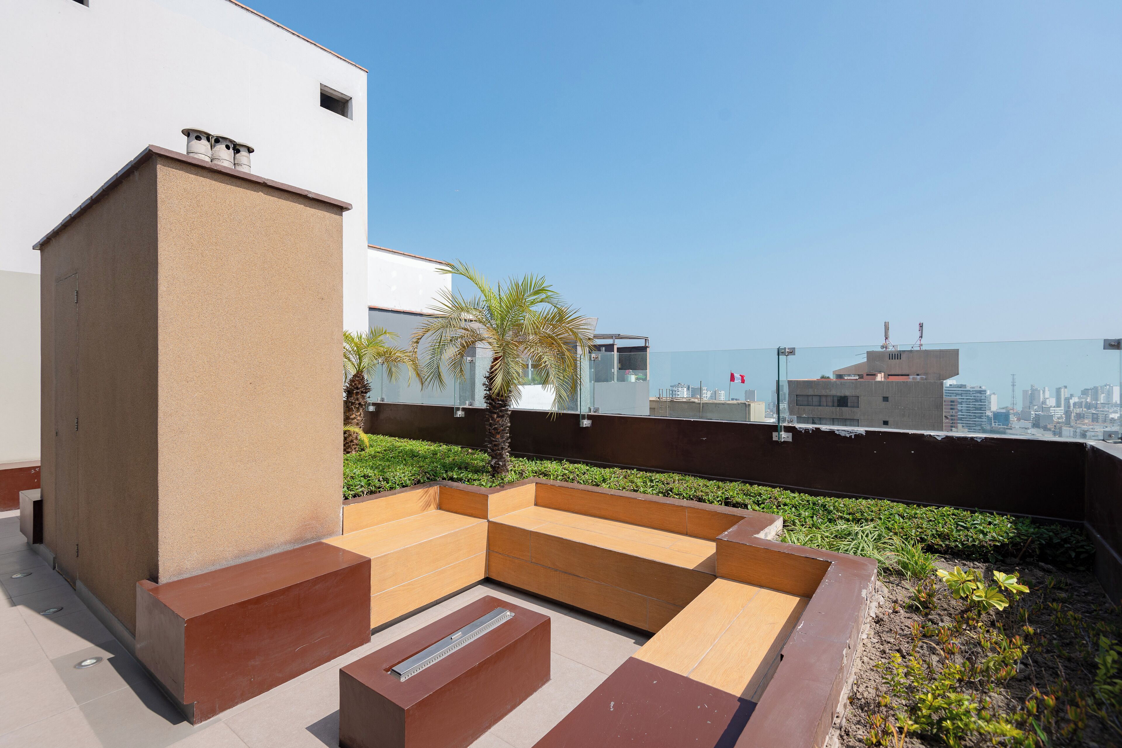 Una terraza en la azotea con zona de estar, un pequeño estanque y vistas del horizonte de la ciudad.