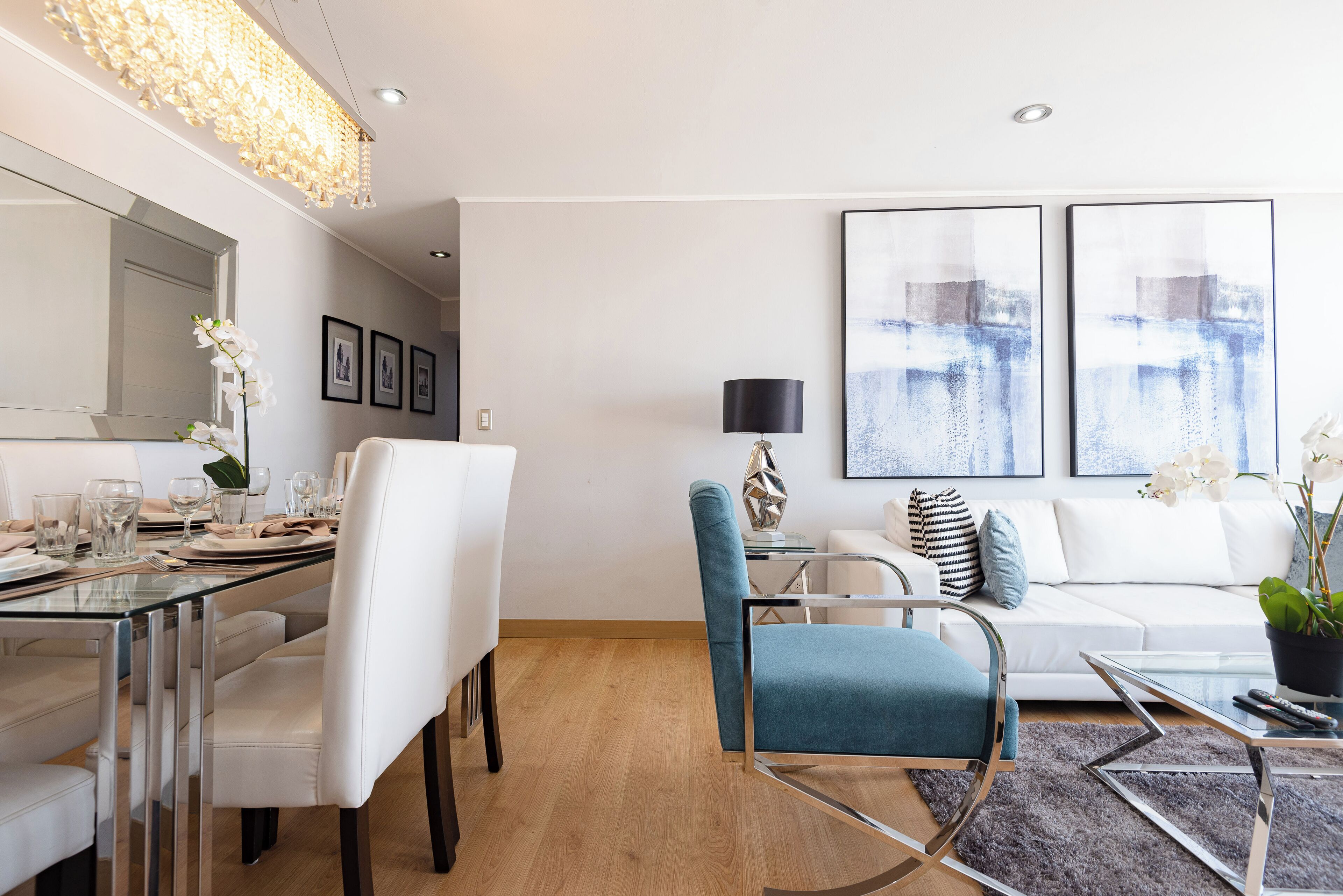 Una sala de estar moderna con comedor, un sofá, una mesa de centro y una lámpara.