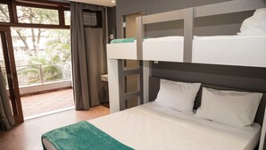 Dormitorio con literas y vistas a un balcón y una ventana.