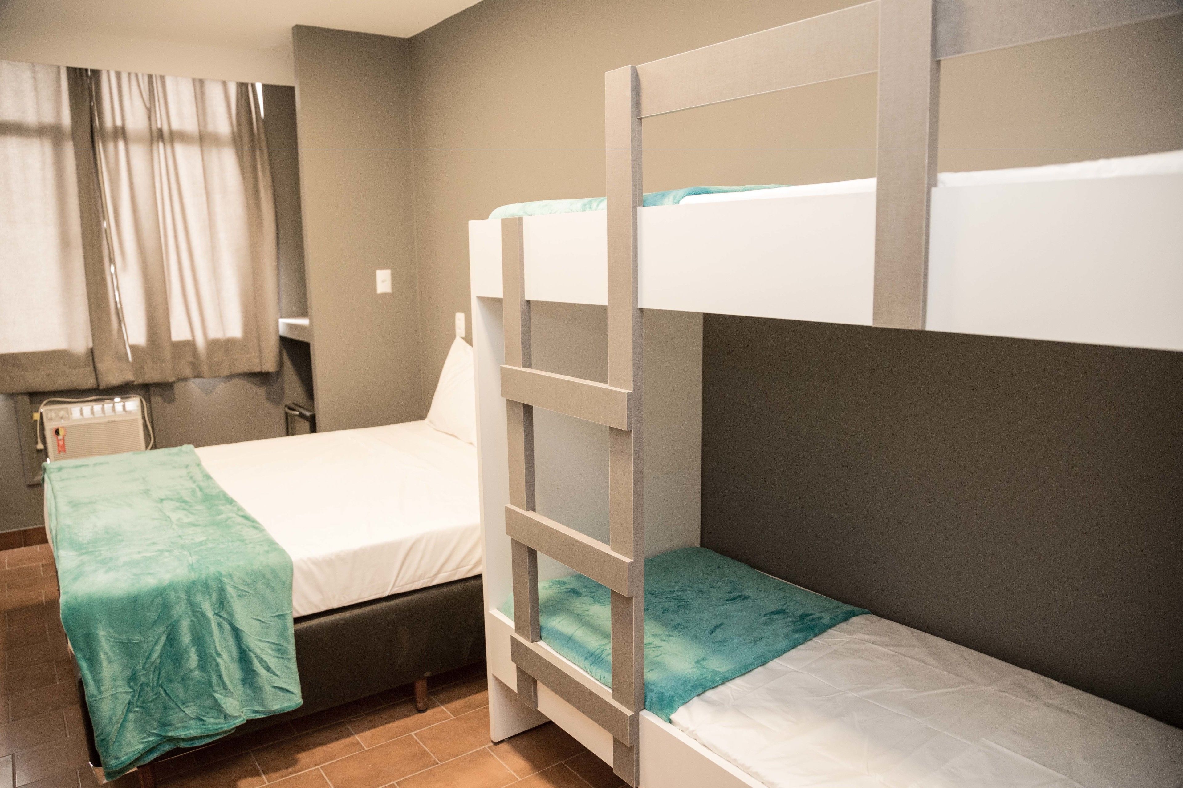 Une chambre avec des lits superposés, un bureau et une chaise.