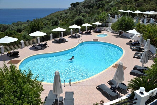 Piscine extérieure, parasols de plage, chaises longues