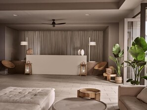 A modern living room with a central island, two side chairs, a sofa, a round coffee table, and a ceiling fan. - The Bay (Zakynthos)