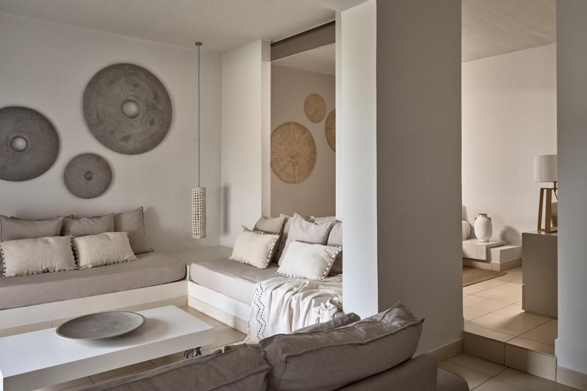Un salon moderne avec un canapé, une table basse et des œuvres d’art décoratives au mur.