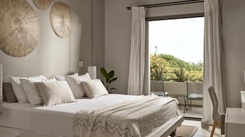 Un dormitorio moderno con una cama grande, vistas a zonas verdes y decoración en la pared.