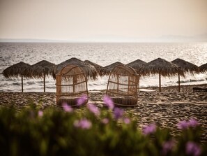 A beach with thatched umbrellas and wicker birdcages. - The Bay (Zakynthos)
