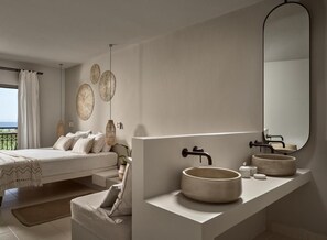 A modern bedroom with a large bed, a built-in vanity with a round sink, and a large mirror.