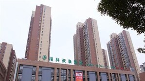A hotel with multiple floors, large windows, and several visible signs. - GreenTree Inn Changzhou Zhongwu Avenue Lihua  Hotel (Changzhou)