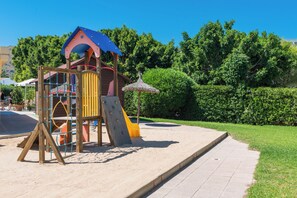 A playground with a slide, climbing structures, and a covered playhouse. - Aparthotel Alcudia Beach (Alcúdia)