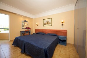 A bedroom with a bed, a nightstand, a chair, a dresser, a mirror, and a picture on the wall. - Aparthotel Alcudia Beach (Alcúdia)