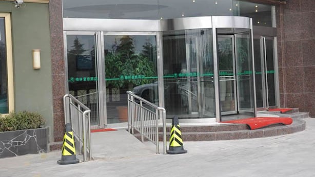 A modern building entrance with glass doors, metal railings, and a red carpet leading to a staircase. - GreenTree Inn XuZhou PiZhou Xinsu Center Fuzhou Road Express Hotel (Xuzhou)