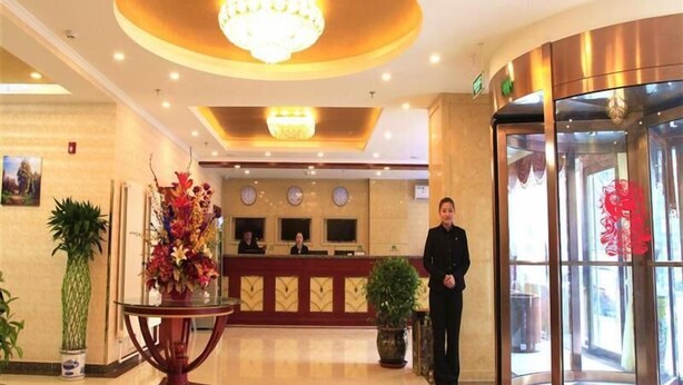 A hotel lobby with a reception desk, a chandelier, and a revolving door. - Greentree Inn Beijing Yanqing Gaota Rd Express Hotel (Yanqing)