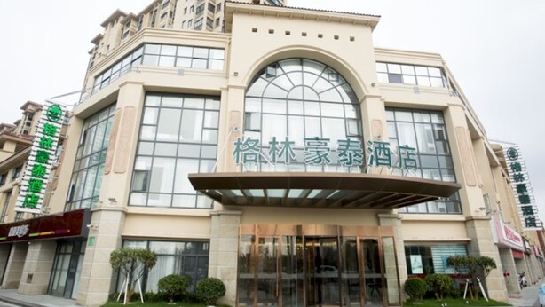 A hotel with a modern facade, large windows, and a prominent entrance. - GreenTree Inn Yancheng Jianhu Oubaoliya Zunyuan Express Hotel (Yancheng)