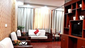 A living room with a sofa, chairs, a coffee table, a TV cabinet, and curtains. - Greentree Inn Suzhou Wangting Zhanwang Business Hotel (Suzhou)