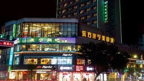 A hotel with multiple floors and a brightly lit facade. - GreenTree Inn JieYang Bus Terminal Station RongHua Avenue Hotel (Jieyang)