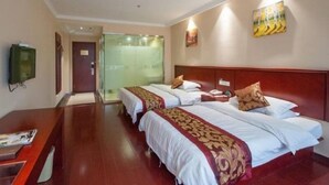 A hotel room with two beds, a wooden desk, a television, and a glass door leading to a bathroom. - GreenTree Inn Nantong Qidong Bus Station Express Hotel (Nantong)