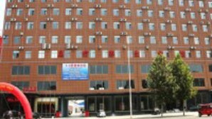 Monikerroksinen hotellirakennus, jossa on tiiliverhous ja lukuisia ikkunoita.