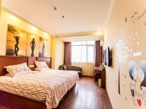 Une chambre d’hôtel avec un grand lit, un bureau avec une chaise et des œuvres d’art accrochées aux murs.