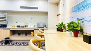 Una cocina moderna con armarios de madera, una isla central y plantas en macetas.