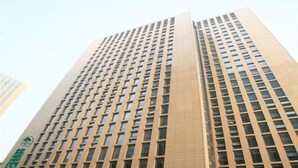 A high-rise building with a grid of windows and a sign indicating a business or office space. - GreenTree Inn Shaoxing Keqiao Xingyue Road Zhongqing Building Hotel (Shaoxing)