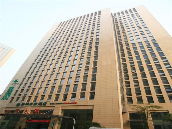 Un immeuble de grande hauteur, doté d’une façade à fenêtres disposées en réseau et d’une enseigne indiquant qu’il s’agit d’un espace commercial ou de bureaux.
