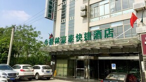 A hotel with a modern facade, a covered entrance, and a flag on top. - GreenTree Inn Yancheng Economic Development Zone Management Committee Express Hotel (Yancheng)