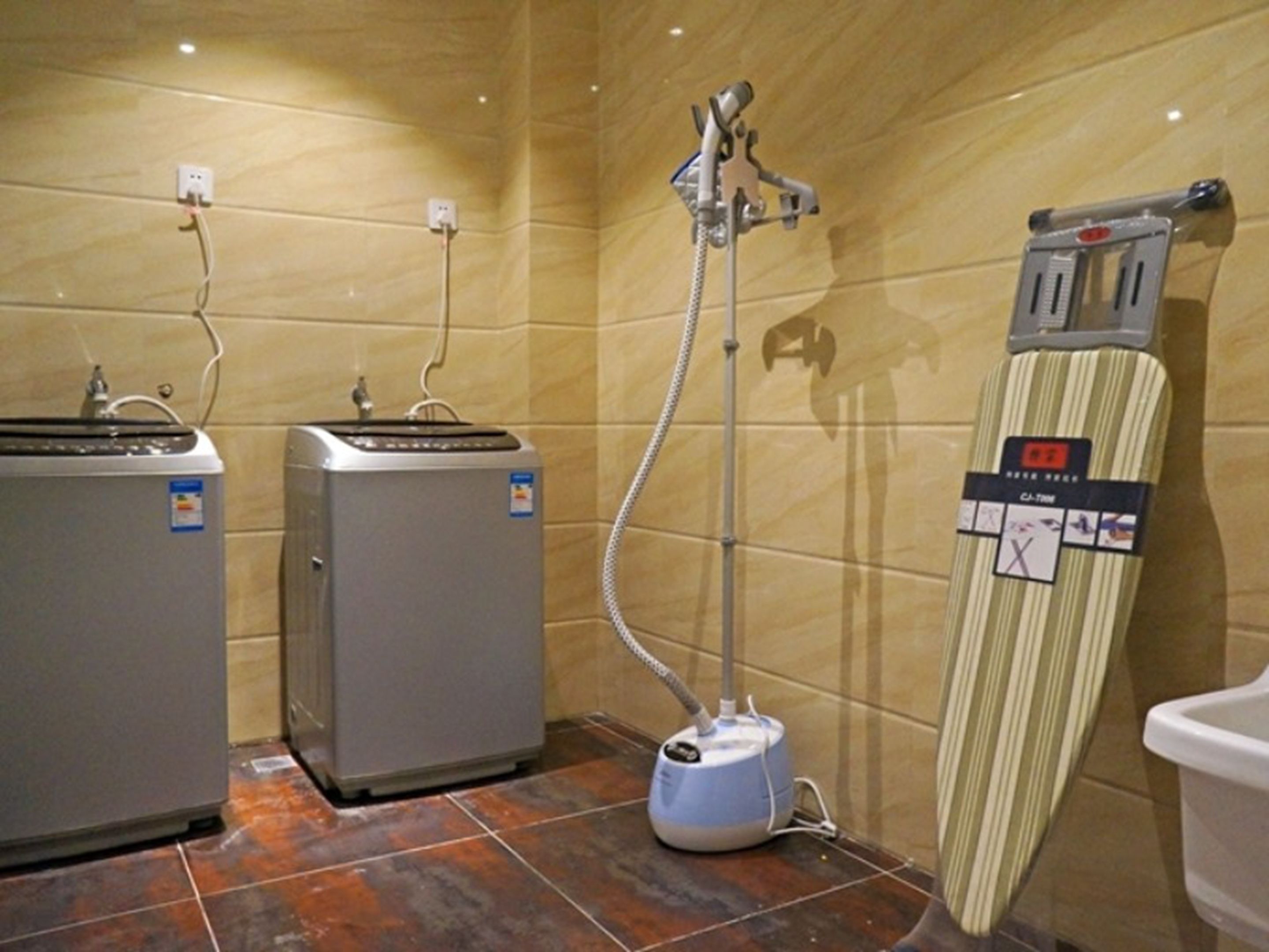 Un baño con dos calentadores de agua, un limpiador a vapor y un perchero para toallas.